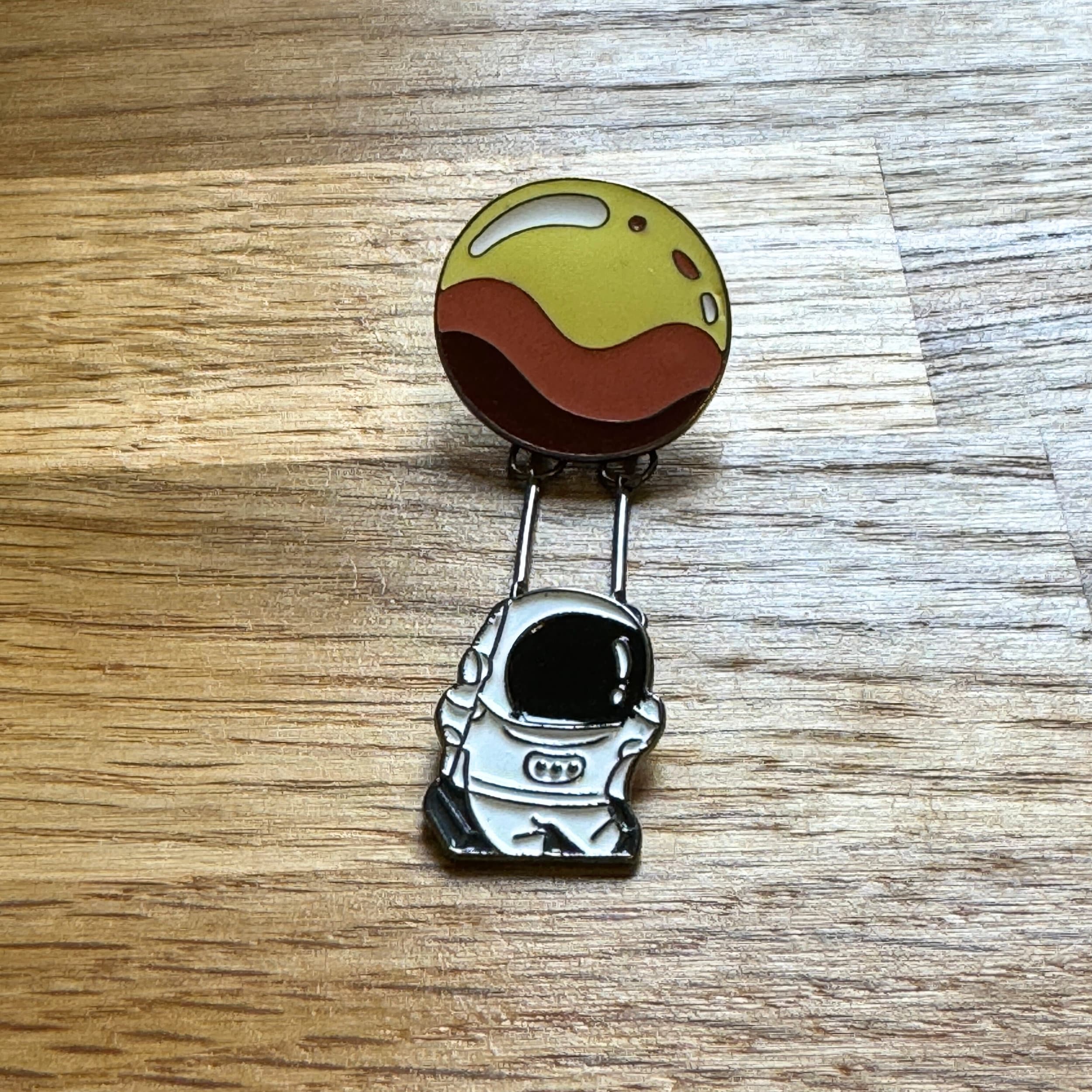 Astronaut Swinging from a Planet Enamel Pin Badge. Dangle Kawaii Space Science Brooch